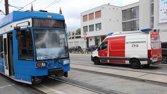 Ein Rettungswagen steht rechts von einer Straßenbahn mit einem beschädigtem Scheinwerfer. © NonstopNews Rostock Foto: Stefan Tretropp