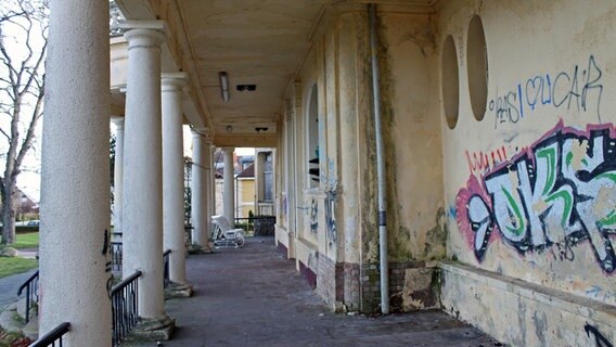 Unter dem Säulengang der "Villa Baltic" blättert der Putz von den Wänden, die mit Graffiti beschmiert sind. © NDR.de Foto: Daniel Sprenger