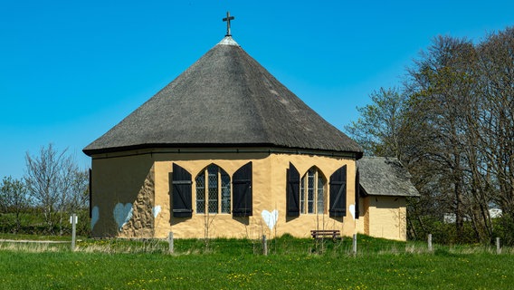 Blick auf die achteckige Kapelle an der Ostseeküste bei Kap Arkona auf Ruegen, im Fischerdorf Vitt. Unbekannte haben aus Protest weiße Herzen an die gelbe Fassade gemalt. Sie fordern entgegen der Empfehlungen des Denkmalschutzamtes einen weißen Anstrich. © IMAGO / photo2000 Foto: IMAGO / photo2000