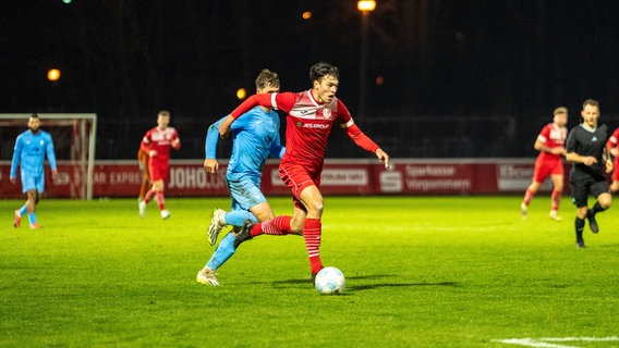 Ein Spieler läuft mit dem Ball vor den Füßen über den Rasen, um ihn herum andere Fußballer. © GFC 
