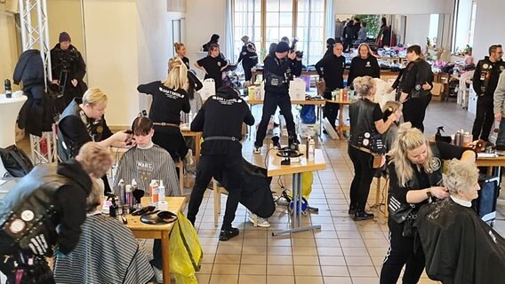 Die schwarz gekleideten Barber Angels schneiden Bedürftigen kostenlos in Stralsund die Haare. Die schwarz gekleideten Barber Angels schneiden Bedürftigen kostenlos in Stralsund die Haare. © Kreisdiakonisches Werk Stralsund e.V. Foto: Kreisdiakonisches Werk Stralsund e.V.