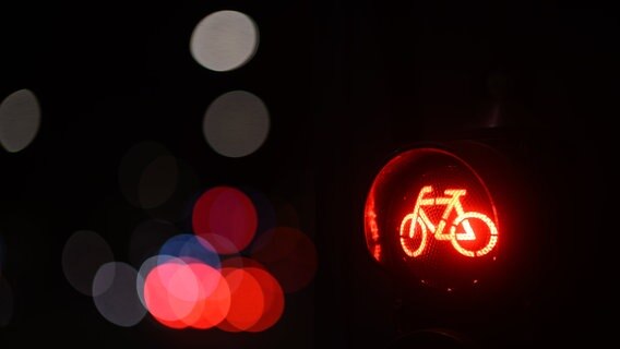 Eine rote Fahrradampel leuchtet am Abend an einer Kreuzung. © Robert Michael/dpa 