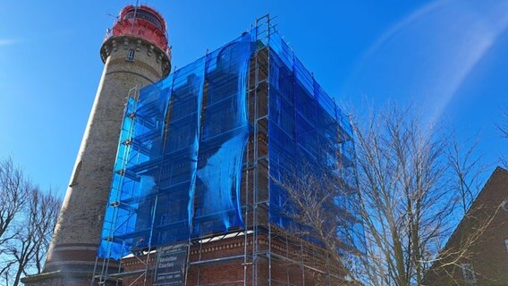 Der Schinkelturm am Kap Arkona ist mit einem Baugerüst und einem blauen Netz verkleidet. Der Schinkelturm am Kap Arkona ist mit einem Baugerüst und einem blauen Netz verkleidet. © Andreas Heinemann