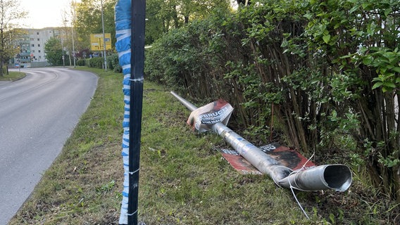 Der umgefahrene Laternenmast liegt am Straßenrand. © NDR Foto: Robert Schubert