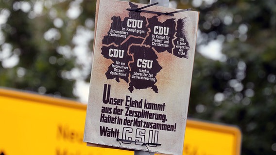 Teterow: An einer Laterne hängt ein Wahlplakat der CDU und CSU für die erste Bundestagswahl 1949 - Deutschland ist in den Grenzen vor dem Zweiten Weltkrieg zu sehen. © dpa-Bildfunk Foto: Bernd Wüstneck