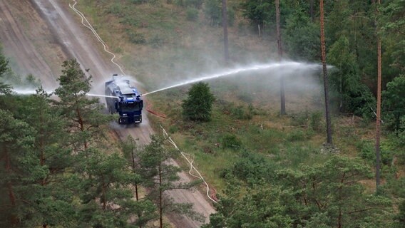 Ein Wasserwerfer der Polizei wässert Bäume im Waldbrandgebiet von Lübtheen © dpa Foto: Jens Büttner
