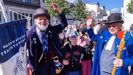 Mitglieder des Warnemünder Trachtenvereins ziehen mit dem farbenfrohen Festumzug "Niege Ümgang" zum Auftakt der 84. Warnemünder Woche durch den Ort. © dpa-Bildfunk Foto: Jens Büttner/dpa