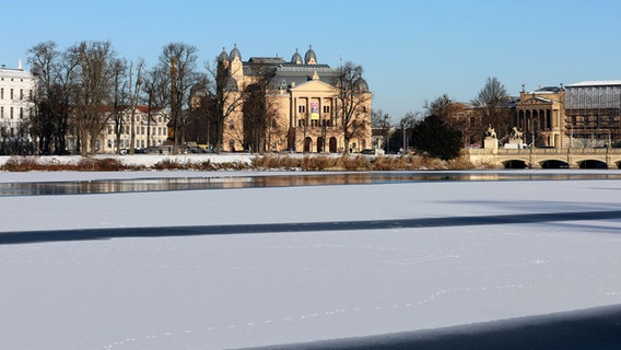 Schwerin: Mit Eis bedeckt ist der Burgsee in der Innenstadt vor dem Mecklenburgischen Staatstheater. © Bernd Wüstneck/dpa +++ dpa-Bildfunk +++ Foto: Bernd Wüstneck/dpa +++ dpa-Bildfunk +++