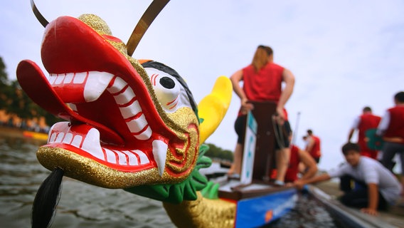 Die goldenen Drachenköpfe sind das Markenzeichen der Riesenpaddelboote, die auch beim Drachenbootfestival in Schwerin starten. © picture alliance/ZB Foto: Jens Büttner