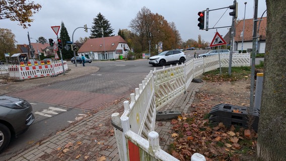 Eine Baustelle entlang der Fahrbahnen einer Kreuzung mit Schildern, Fahrzeugen und weiß-roten Straßenbaken Eine Baustelle entlang der Fahrbahnen einer Kreuzung mit Schildern, Fahrzeugen und weiß-roten Straßenbaken © Christoph Loose Foto: Chris Loose