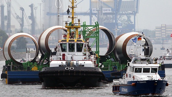 Ein Schleppverband transportiert in Rostock-Warnemünde Fundamente für Offshore-Windkraftanlagen auf die Ostsee. © dpa-Bildfunk Foto: Bernd Wüstneck