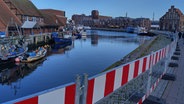 Absperrungen umgrenzen einen durch Hochwasser beschädigten Bereich der Wismarer Hafenpromenade. Die Hansestadt ist von größeren Schäden verschont geblieben. © NDR Foto: Christoph Woest