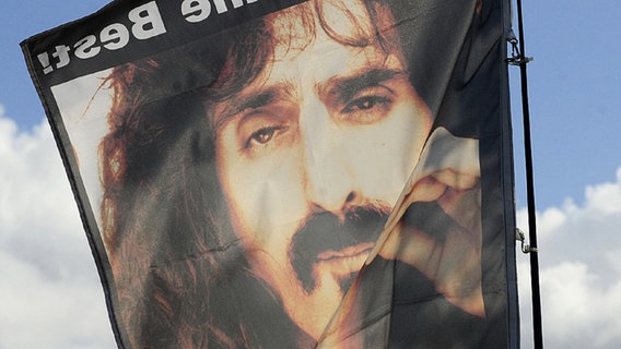 Eine Fahne mit dem Foto von Frank Zappa und der Aufschrift "Music is the Best" © dpa Foto: Klaus-Dietmar Gabbert