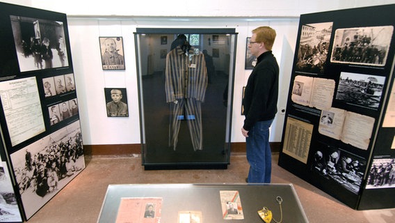 Ein Mann sieht sich Dokumente einer Ausstellung über Zwangsarbeiter aus Polen an.  Foto: Stefan Sauer