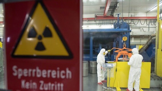 Arbeiter in Schutzanzügen lagern im Zwischenlager Nord in Lubmin bei Greifswald die Überreste der Atomkraftwerke Lubmin und Rheinsberg ein. © dpa-Zentralbild Foto: Stefan Sauer/dpa