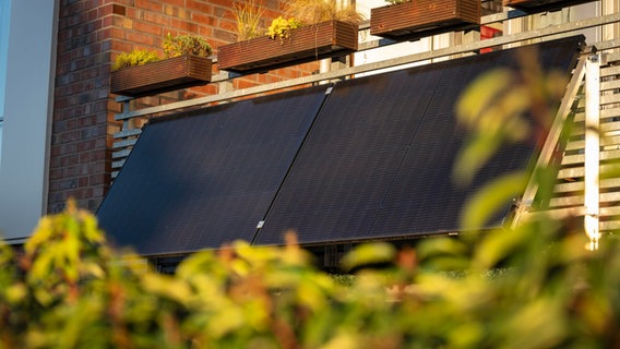 Eine Mini-Solaranlage ist an einem Balkon befestigt © am 11.01.24 heruntergeladen 