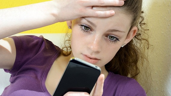Teenagerin schaut entsetzt auf ihr Smartphone © Fotolia.com Foto: gemphotography