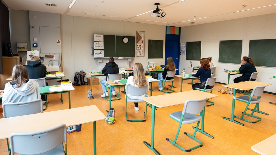 Schüler warten in einem Klassenzimmer auf den Beginn einer schriftlichen Abiturprüfung.