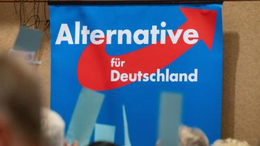 Auf einem AfD-Landesparteitag hängt ein Plakat mit dem Schriftzug «Alternative für Deutschland». © picture alliance/dpa Foto: Stefan Sauer
