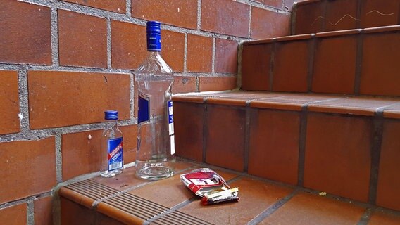 Eine leere Schnapsflasche steht auf einer Treppe. © picture alliance/blickwinkel/fotototo 