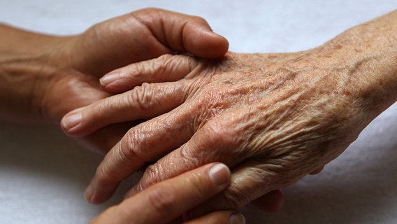 Eine Pflegerin massiert die Hände einer Seniorin. © dpa-Bildfunk Foto: Oliver Berg