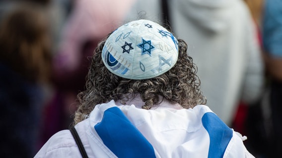 Eine Frau trägt auf einer Kundgebung eines Bündnisses gegen Antisemitismus eine Kippa © picture-alliance/dpa Foto: Christophe Gateau