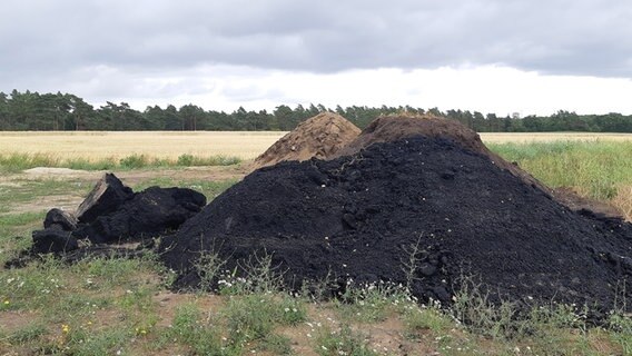 Ein Asphalthaufen liegt auf einem Acker. © NDR Foto: Marie Schiller