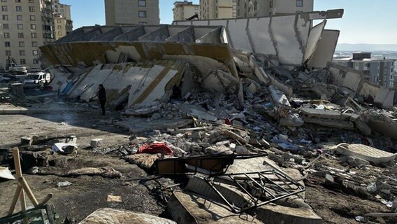 Ein Mensch steht nach Erdbeben in der Türkei zwischen zertrümmerten Gebäuden. © @fire 