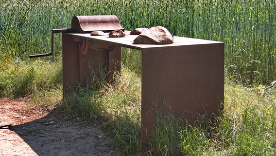 Auf einem verrosteten Metallltisch liegen mehrere glatt geschliffene Steine. © Gemeinde Wedemark Foto: Gemeinde Wedemark