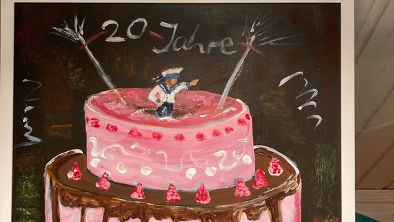Ein Gemälde zeigt eine rosafarbene Geburtstagstorte © NDR Foto: Jörn Pietschke