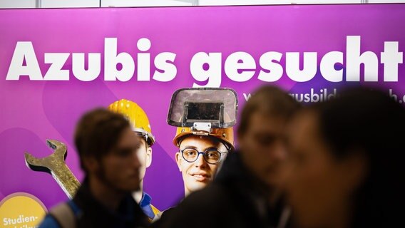 Besucher stehen auf der Jobmesse "KarriereStart" in Dresden vor dem Schriftzug "Azubis gesucht". © dpa-Bildfunk Foto: Sebastian Kahnert