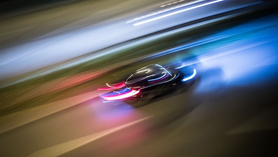 Das Bild zeigt ein Auto fahrend, in der Bewegungsunschärfe. © picture alliance/dpa Foto: Frank Rumpenhorst