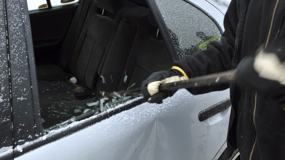 Ein Mann schlägt eine Autoscheibe ein. © picture-alliance/ dpa Foto: Lehtikuva Matti Björkman