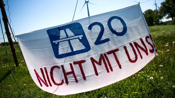 Ein Plakat mit der Aufschrift «A20 Nicht mit uns!» hängt vor einem Protestcamp. © picture alliance/dpa | Sina Schuldt Foto: Sina Schuldt