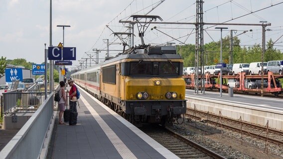Fahrgäste stehen an einem Gleis vom Bahnhof in Bad Bentheim vor einem Zug aus den Niederlanden. © picture alliance/dpa | Friso Gentsch Foto: Friso Gentsch