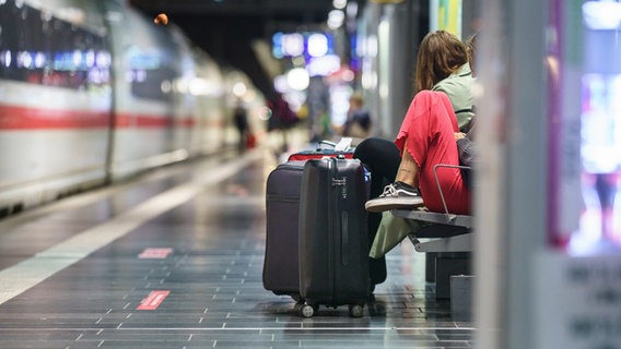 Two women are waiting with their suitcases in a train station early in the morning.  © dpa-Bildfunk Photo: Frank Rumpenhorst