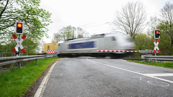 Ein Zug passiert den Bahnübergang, an dem am Sonntagmorgen ein Auto von einem Zug erfasst worden war. © dpa-Bildfunk/dpa Foto: Julian Stratenschulte