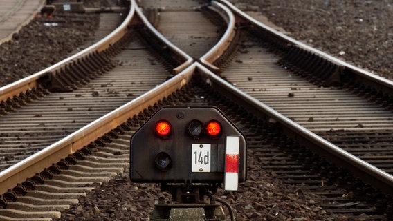 Ein Bahn-Signal leuchtet rot vor einer Weiche. © dpa-Bildfunk Foto: Julian Stratenschulte