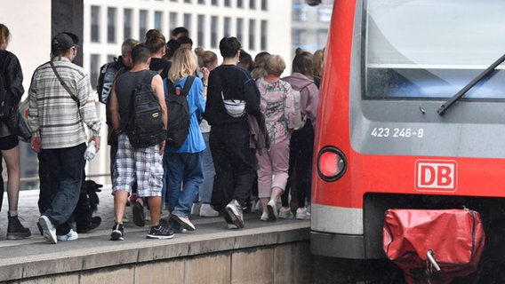 Zahlreiche Menschen laufen zu einem Regionalzug. © picture alliance/dpa | Roberto Pfeil Foto: Roberto Pfeil