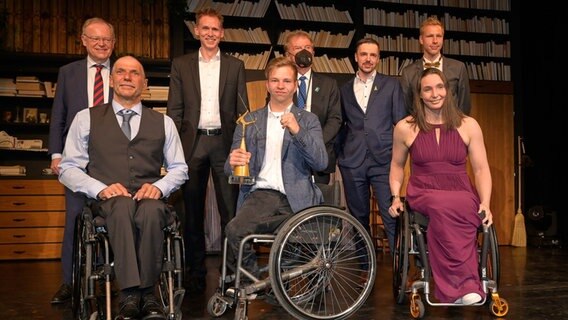 Niedersachsens Ministerpräsident, Stephan Weil (SPD, v.h.l.), Ex-Zehnkämpfer Frank Busemann, Para Tischtennisspieler Björn Schnake, Para Sportschütze Tim Focken, Para Leichtathlet Alexander Bley, Handbiker Bernd Jeffré Rollstuhltennisspieler Christoph Wilke, Rollstuhlbasketballerin Mariska Beijer Sportlerinnen und Sportler stehen nach der Wahl des Behindersportler*in des Jahres 2022 zusammen auf einer Bühne. © Volker Minkus/BSN Foto: Volker Minkus