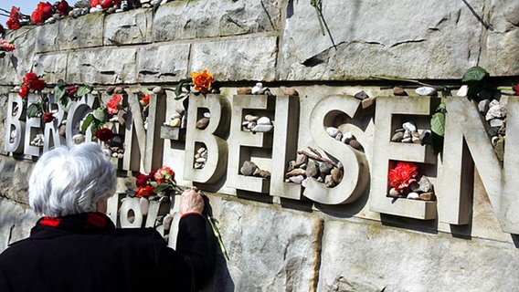 Blumen an einem Gedenkstein in Bergen-Belsen. Archivbild 2013. © picture-alliance/ dpa/dpaweb Foto: Rainer Jensen