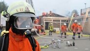 Die freiwillige Feuerwehr muss bei Löscharbeiten an einem Kindergarten und einer kleinen Turnhalle im Berner Ortsteil Ganspe (Landkreis Wesermarsch) mit Atemmasken arbeiten. © dpa Foto: Carmen Jaspersen