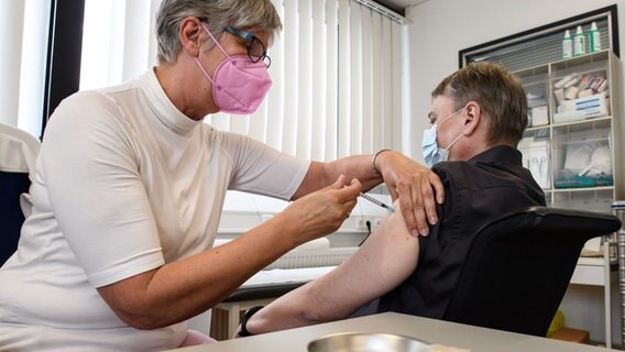 Eine Betriebsärztin impft einen Angestellten gegen das Coronavirus. © picture-alliance Foto: Swen Pförtner