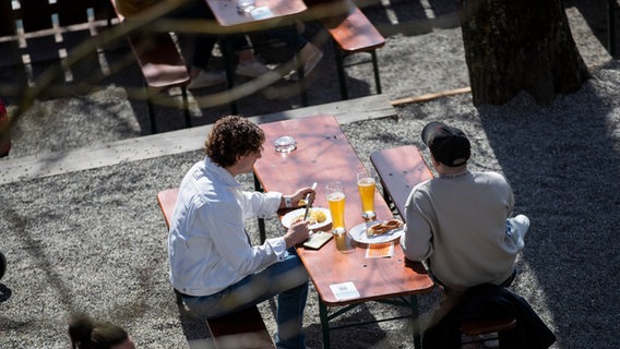 Zwei Männer sitzen bei gutem Wetter in einem Biergarten. © picture alliance/dpa/Tom Weller Foto: Tom Weller