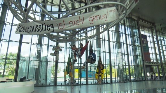 Umweltaktivisten hängen an einer Metallkonstruktion in der Autostadt in Wolfsburg. © NDR 