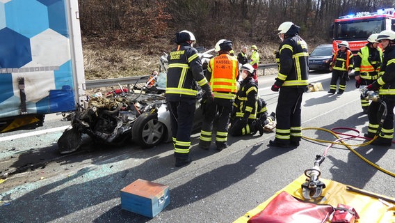 Einsatzkräfte der Feuerwehr stehen an einer Unfallstelle auf der A7. © dpa/Feuerwehr Kassel 