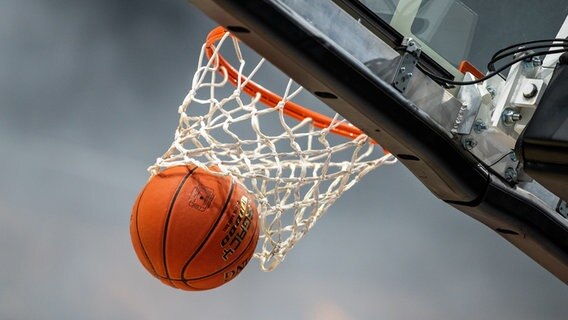 Ein Basketball fliegt durch einen Korb. © picture alliance/Andreas Gora Foto: Andreas Gora