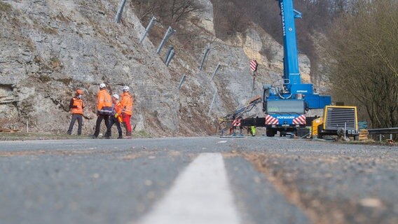 Arbeiter sichern eine Felswand an einer Landstraße. © picture alliance Foto: Julian Stratenschulte