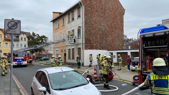 Feuerwehrleute sind mit einem Leiterwagen an einem Mehrfamilienhaus im Einsatz. © Feuerwehr Helmstedt 
