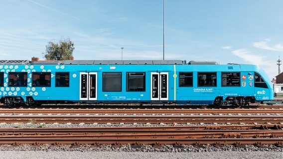 Ein mit Wasserstoff betriebener Brennstoffzellenzug steht auf Bahngleisen. © evb Foto: René Frampe